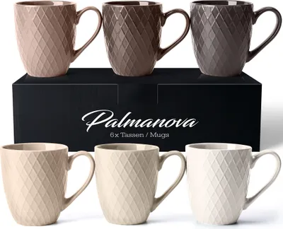 A set of ceramic mugs displayed on a black box with the brand name and product details.