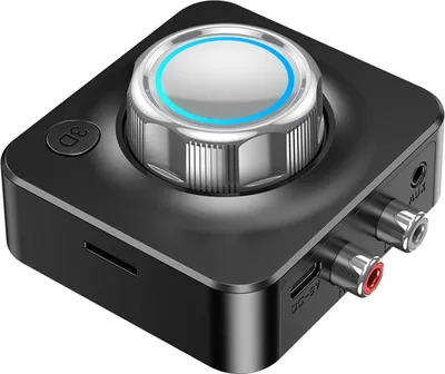 A close-up, angled view of a black audio receiver with a large silver dial on top and various ports on the side.