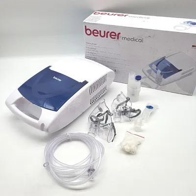 A Beurer medical inhalator and its accessories are displayed on a white surface, with the product's packaging in the background.