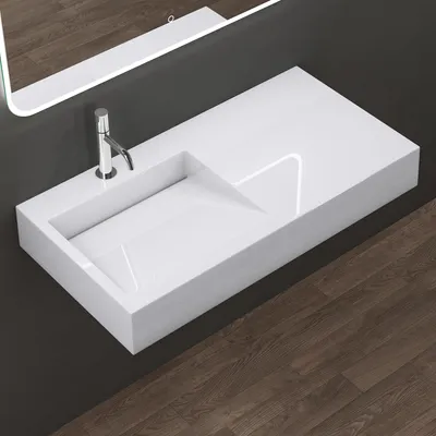 A modern white washbasin with a chrome faucet, mounted on a dark gray wall, with a wooden floor.