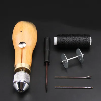 A set of leather sewing tools laid out on a black background.
