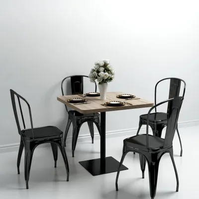 A square dining table with four chairs set up in a room with a white wall.