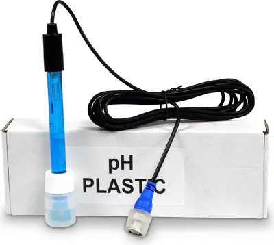 A pH sensor probe with a cable and a small bottle is placed on a white box.