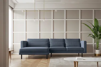 A modern living room with a blue sectional sofa, a coffee table, and a large plant.