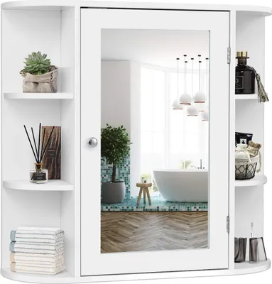 A white bathroom cabinet with a mirror is shown against a white background. The cabinet has shelves on the sides and a mirrored door in the center. The reflection in the mirror shows a modern bathroom interior with a bathtub and pendant lights.