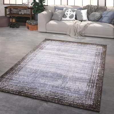 A living room scene with a sofa, rug, and some exercise equipment.