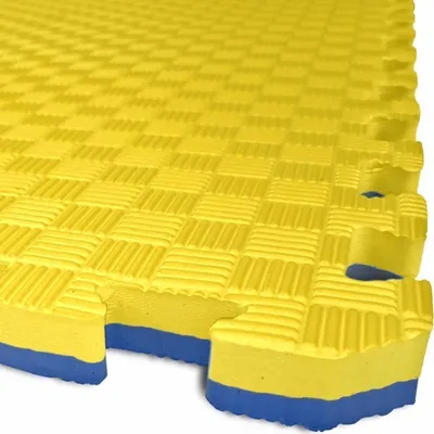 A close-up, angled view of interlocking yellow and blue foam puzzle mats.