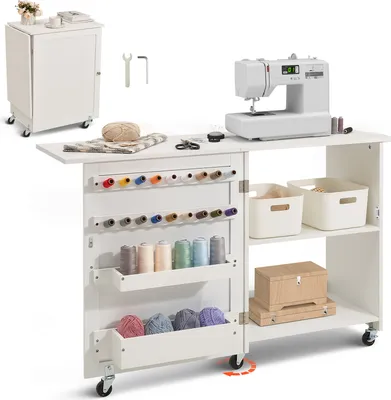 A white sewing table with a sewing machine, spools of thread, and storage bins.