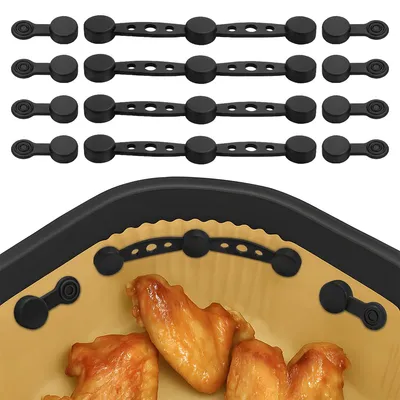 A set of black silicone magnets for an air fryer, shown with some chicken wings in the foreground.