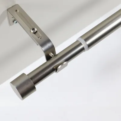 Close-up view of a metal curtain rod with a bracket and end cap.