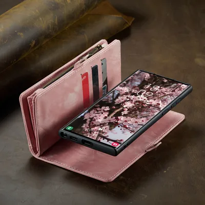 A pink leather wallet case for a Samsung phone is shown open, with the phone displaying a floral wallpaper. The background is a textured brown surface.