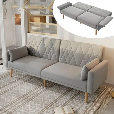 A gray sofa bed is shown in a living room setting with a rug and books.