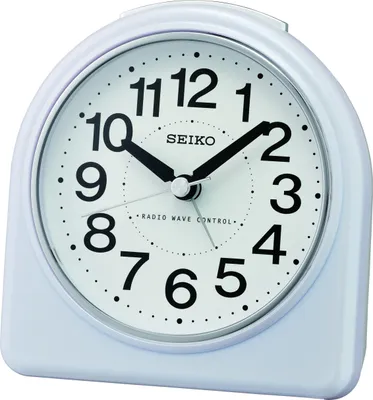 A white Seiko alarm clock with a white face and black numbers and hands.