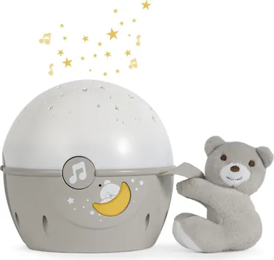 A baby night light projector and a teddy bear on a white background.