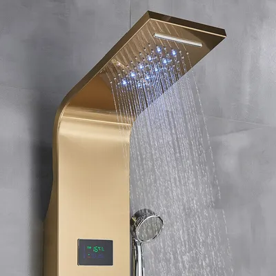 A close-up view of a modern gold shower panel with LED lights and water flowing.