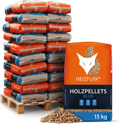 A stack of bagged wood pellets on a pallet next to a single bag of wood pellets and a pile of loose pellets.