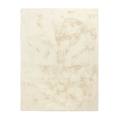 A flat lay of a cream-colored, high-pile rug with a faux rabbit fur texture.