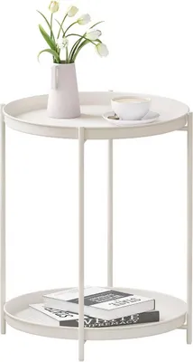 A white side table with two tiers, holding a vase of tulips and a cup of coffee on the top tier, and books on the bottom tier.