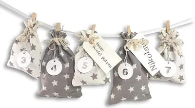 A string of small fabric bags with star patterns, each attached to a clothesline with clothespins.