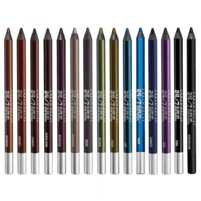 A collection of Urban Decay 24/7 Glide-On Eye Pencils in various colors, arranged in a row against a white background.