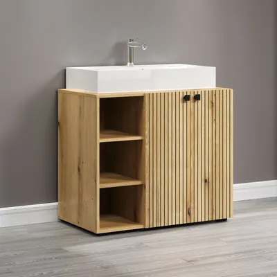 A bathroom vanity with a sink and faucet against a gray wall.