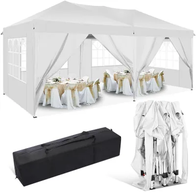 A white party tent set up with tables and chairs inside, along with a folded tent and a carrying bag.
