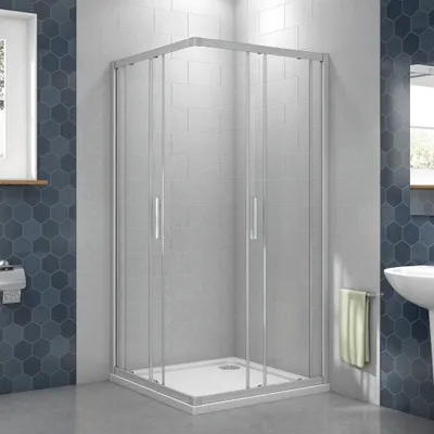 A modern bathroom with a corner shower enclosure.