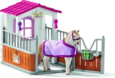 A toy horse stable with a horse inside.