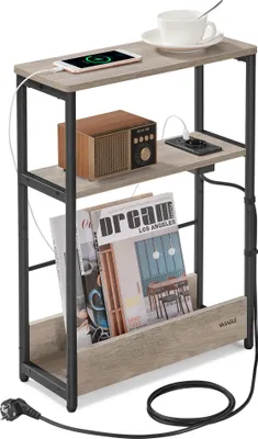 A narrow side table with three shelves, featuring a built-in charging station and a magazine rack. It is shown with a smartphone, a vintage-style radio, a cup and saucer, and magazines.