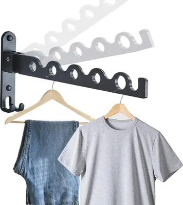A wall-mounted drying rack holding clothes hangers with jeans and a t-shirt.