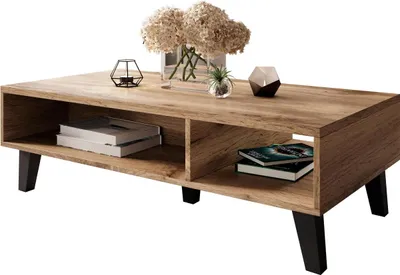 A coffee table with storage shelves, decorated with books, a vase of flowers, and decorative objects.