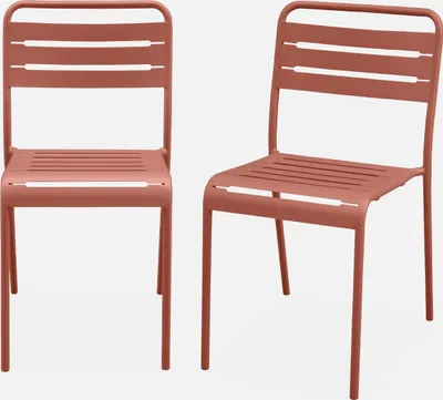 Two terracotta colored metal garden chairs are shown against a white background.