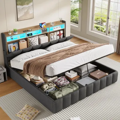 A modern hydraulic bed with LED lighting and storage, shown with the bed frame lifted to reveal storage compartments filled with various items.