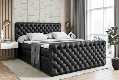 A luxurious black tufted bed with white bedding in a modern bedroom setting.