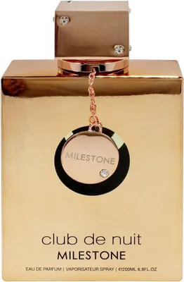 A close-up front view of a gold-colored perfume bottle with a decorative charm hanging from the cap.