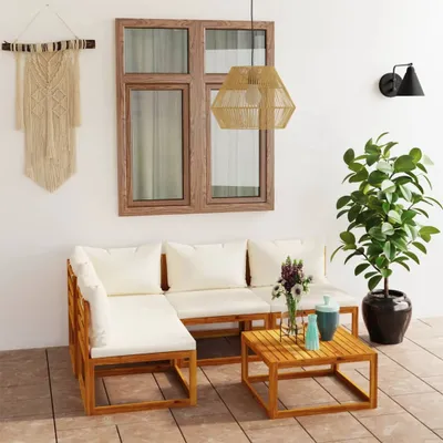 An outdoor patio setting with a wooden lounge set, coffee table, and plant.
