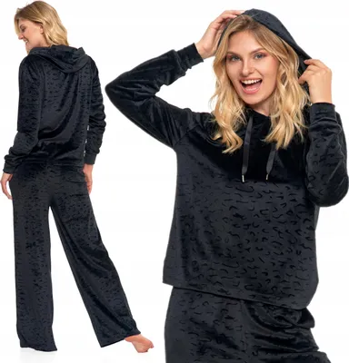 A woman modeling a black velour pajama set with a leopard print.