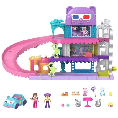A toy playset with a slide, movie theater, and accessories, along with two dolls and a car.