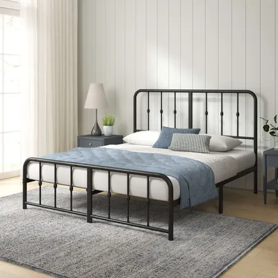 A black metal bed frame with a mattress and bedding in a bedroom setting.