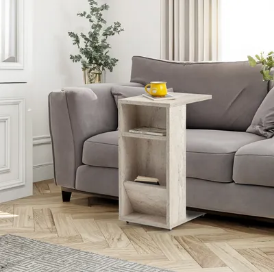 A side table with shelves is placed next to a gray sofa in a living room.
