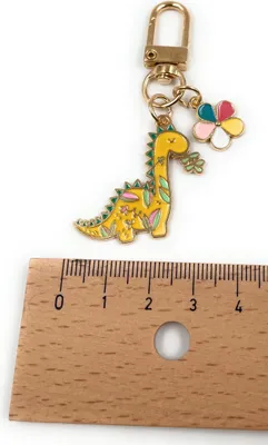 Obrázek produktu pro Kovový přívěsek na klíče Onwomania dinosaurus se žlutým květem, talisman v hliníkové dárkové krabičce, ideální jako dárek