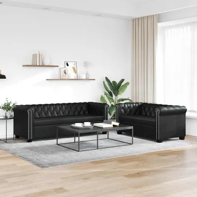 A living room setting with two black leather sofas and a coffee table.