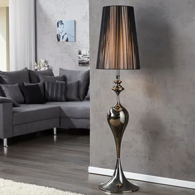 A modern living room with a grey sectional sofa and a decorative floor lamp.