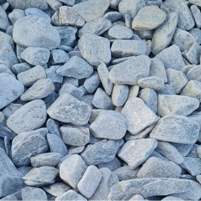 Graue flache Kieselsteine dicht aneinander liegend im Detail