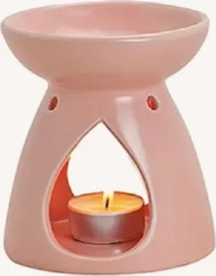 Eine rosa Keramik-Duftlampe mit schalenförmiger Oberseite und tropfenförmiger Öffnung in der Mitte.