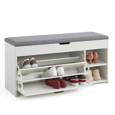 A white shoe cabinet with a gray upholstered seat on top, filled with various shoes.