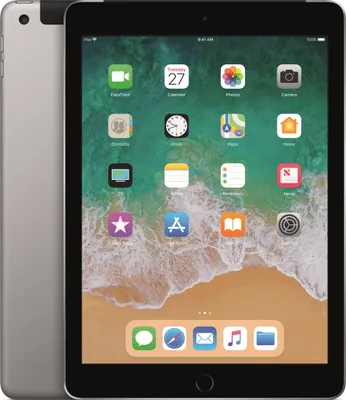 A silver iPad with a black screen displaying various app icons and a beach-themed wallpaper.