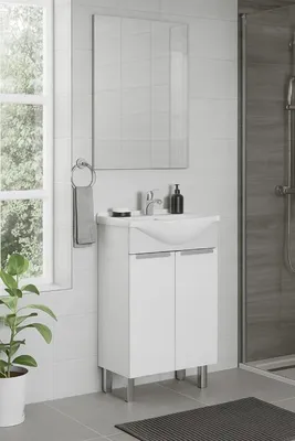 A modern bathroom vanity with a sink and faucet, set against a tiled wall with a window and a shower in the background.