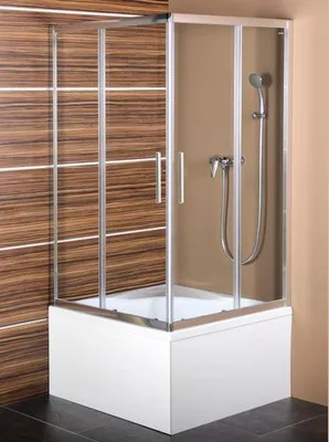 A shower enclosure with a shower head and controls, installed over a bathtub. The background features wood-look tiles and a plain wall.