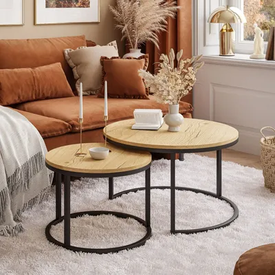A living room scene with a sofa, coffee tables, and decor.